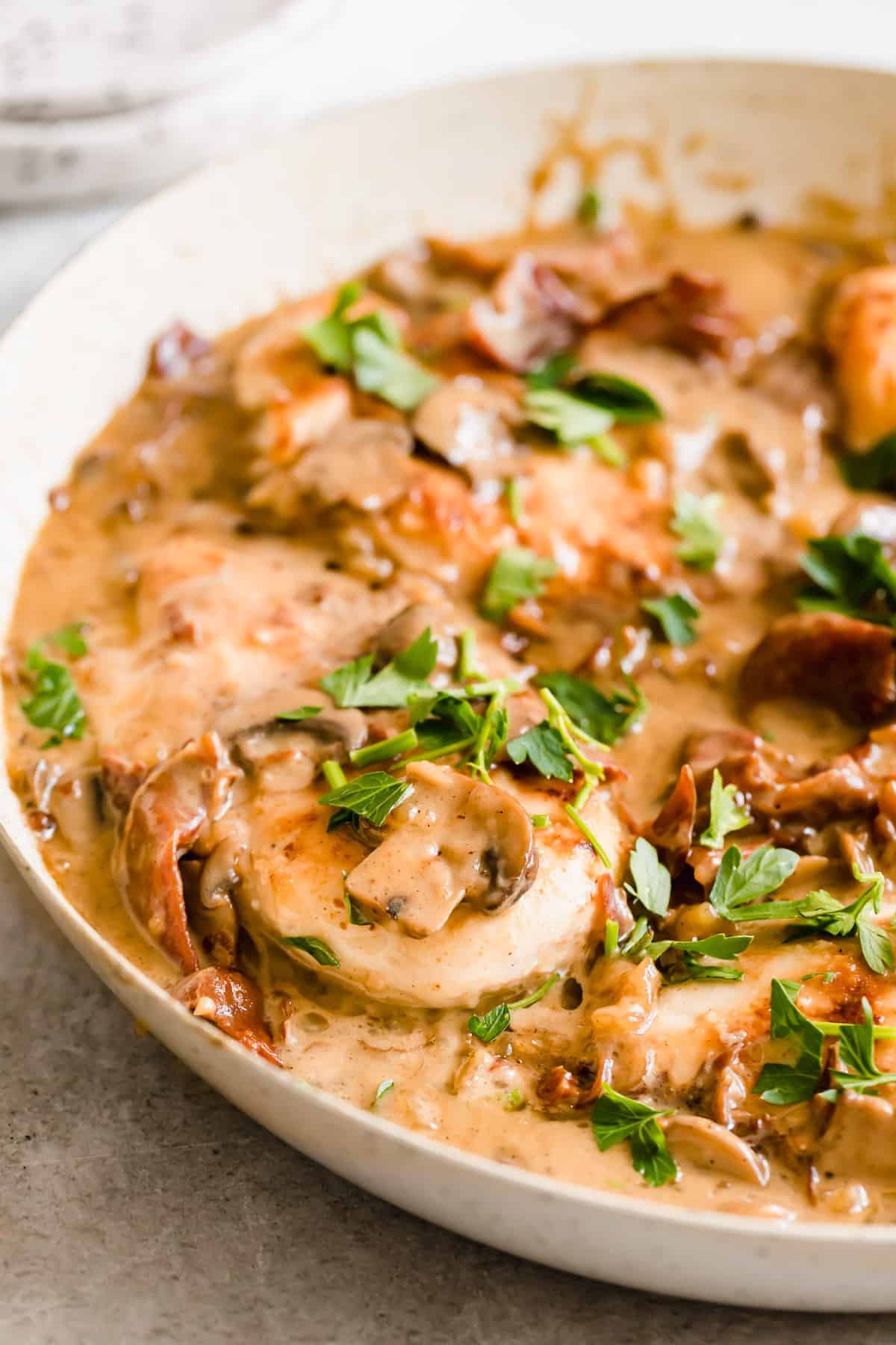Chicken in a creamy sauce with sliced mushrooms and fresh herbs.