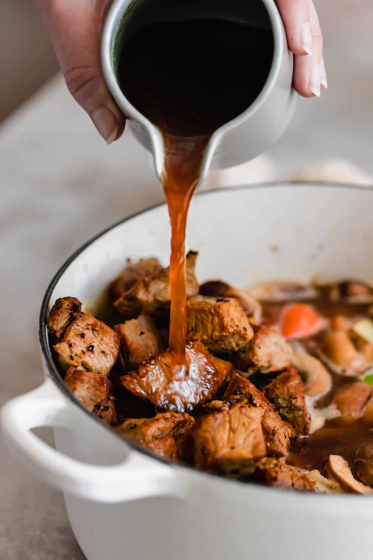 Guinness beer being poured into beef stew.