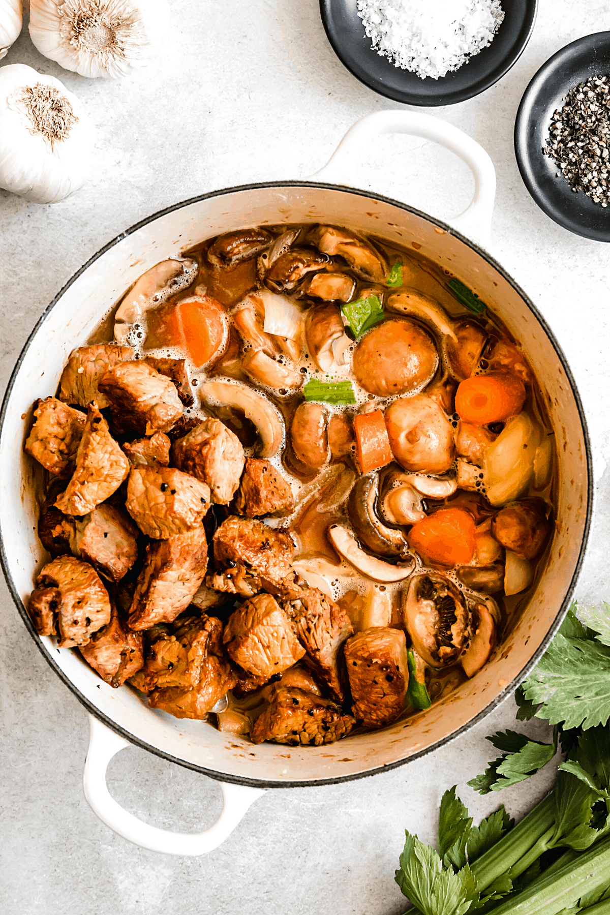 overhead shot of guinness beef stew in a white dutch oven