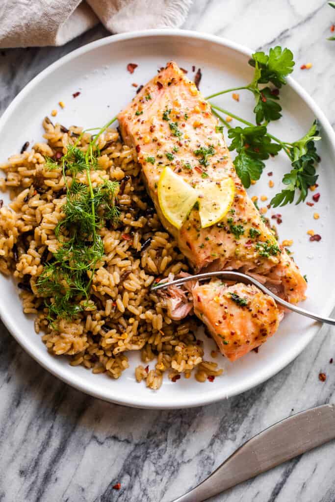 salmon fillet on white plate served with wild brown rice