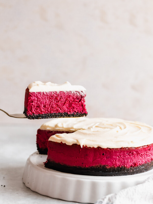 A Slice of Red Velvet Cheesecake Being Lifted From the Rest of the Cake with a Spatula