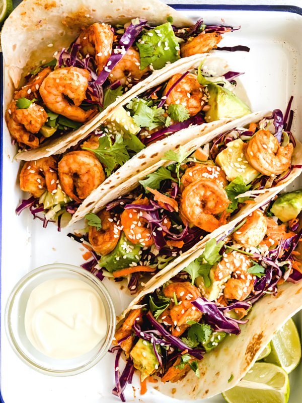 Four Shrimp Tacos Topped with Asian Slaw on a Serving Platter