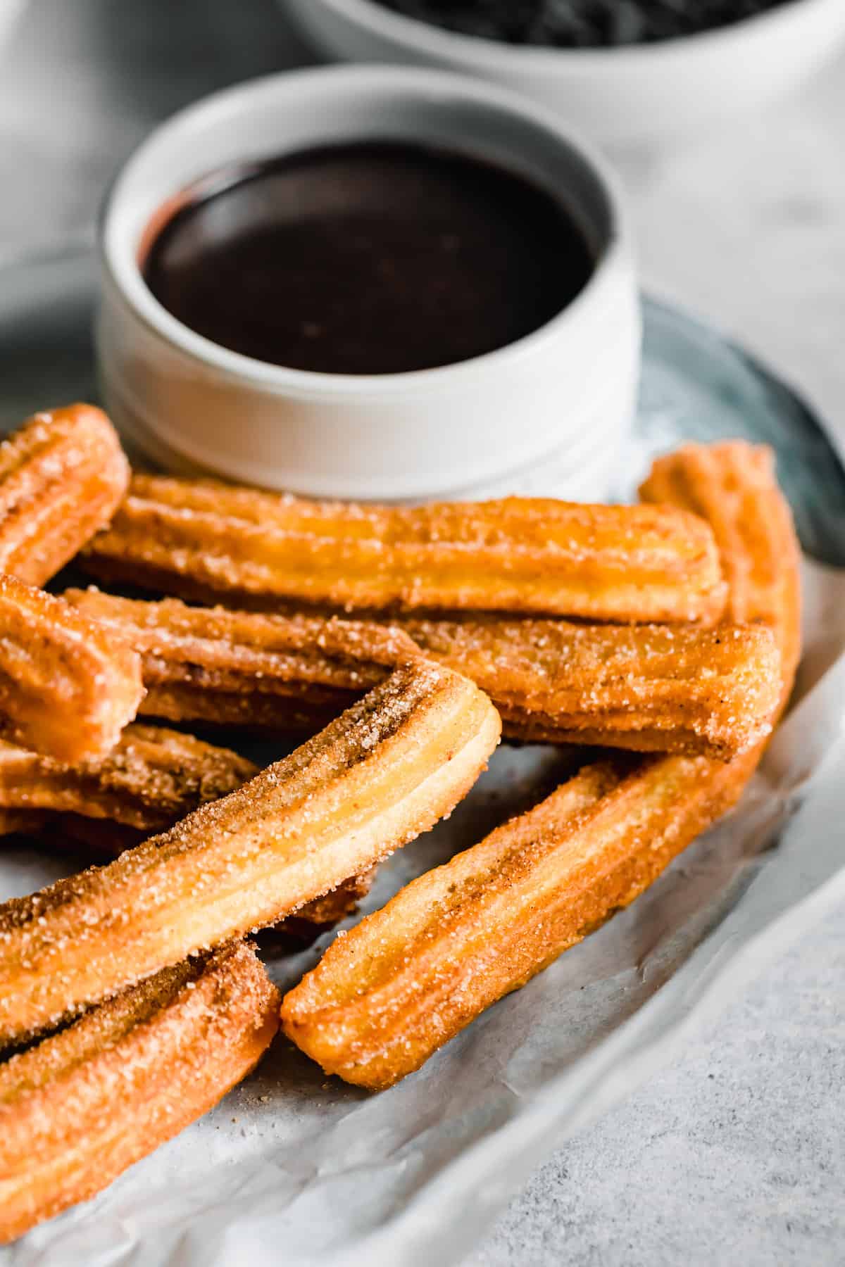 A Plate of Homemade Churros Next to a Dish of Chocolate Sauce