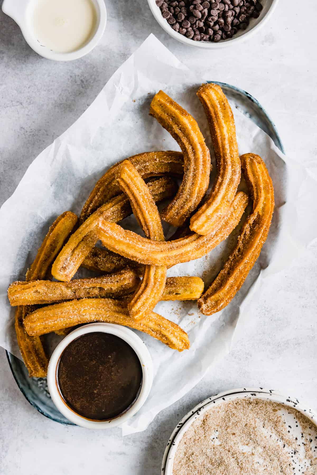 A Parchment-Lined Basket Filled with Churros and Chocolate Dipping Sauce