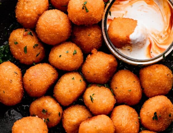 overhead shot of Jalapeno Popper Balls in a black bowl with a Dipping Sauce