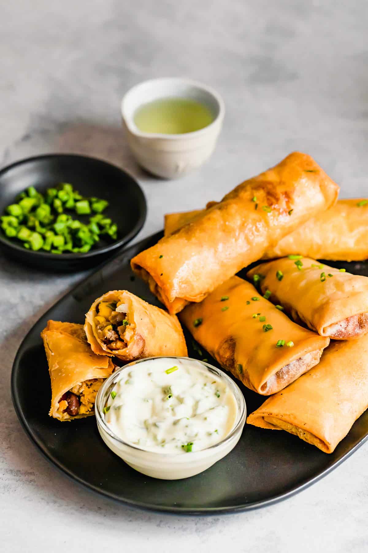 A Plate of Egg Rolls with a Glass Dish of Dipping Sauce