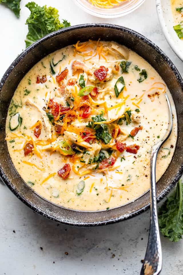 creamy crack chicken soup in a black bowl served with a spoon