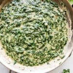 overhead picture of creamed spinach cooking in a large skillet.