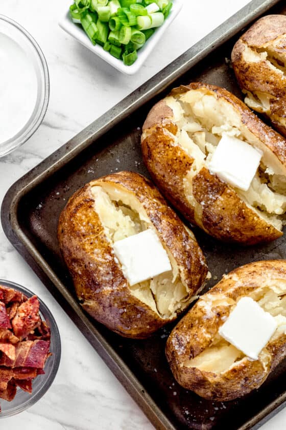 Instant Pot Baked Potatoes on a Pan with a Square of Butter on Top of Each One