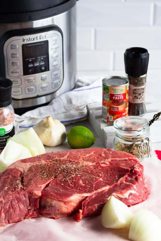 An Instant Pot, Tomato Paste, a Chuck Roast, Onions, a Lime and the Other Beef Barbacoa Ingredients