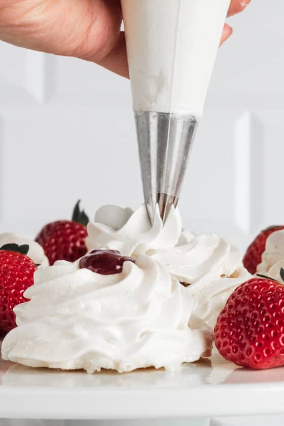 A hand piping whipped cream