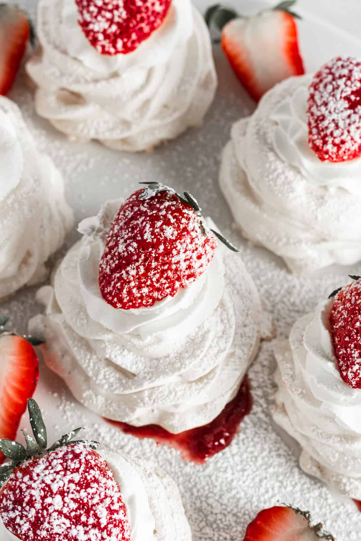 Pavlovas topped with strawberries and powdered sugar