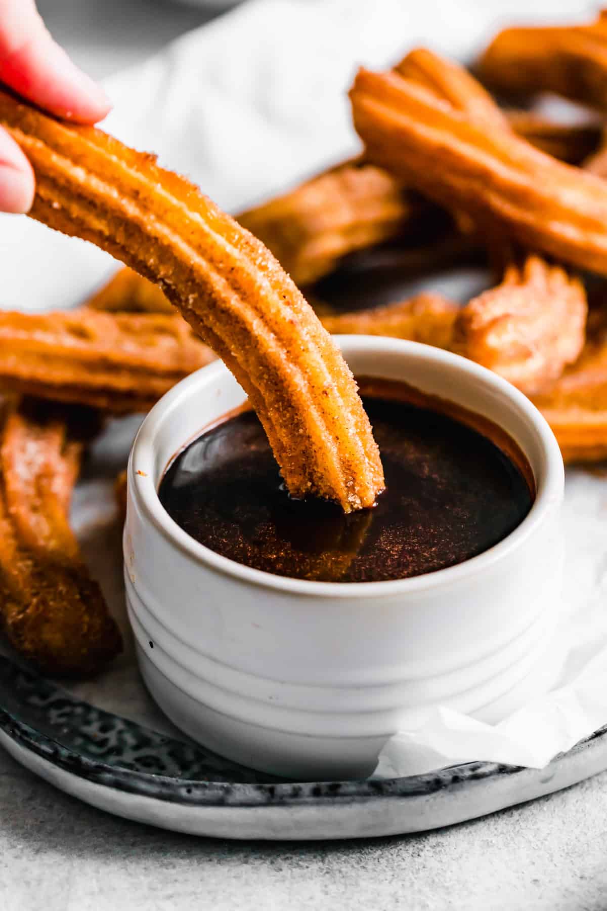 Dipping churros in chocolate sauce. Recipe by Easy Weeknight Recipes.