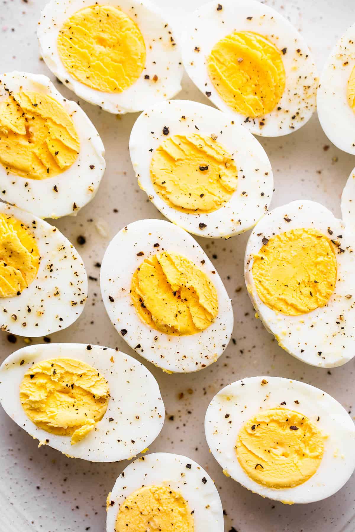 halved hard boiled eggs topped with cracked black pepper