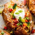 Three Instant Pot Baked Potatoes Beside Bowls of Cheese, Broccoli, Bacon, Chopped Green Onions and Sour Cream