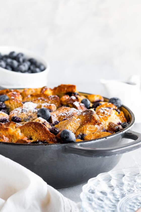A Baked Blueberry French Toast Casserole in a Round Pan Topped with Powdered Sugar