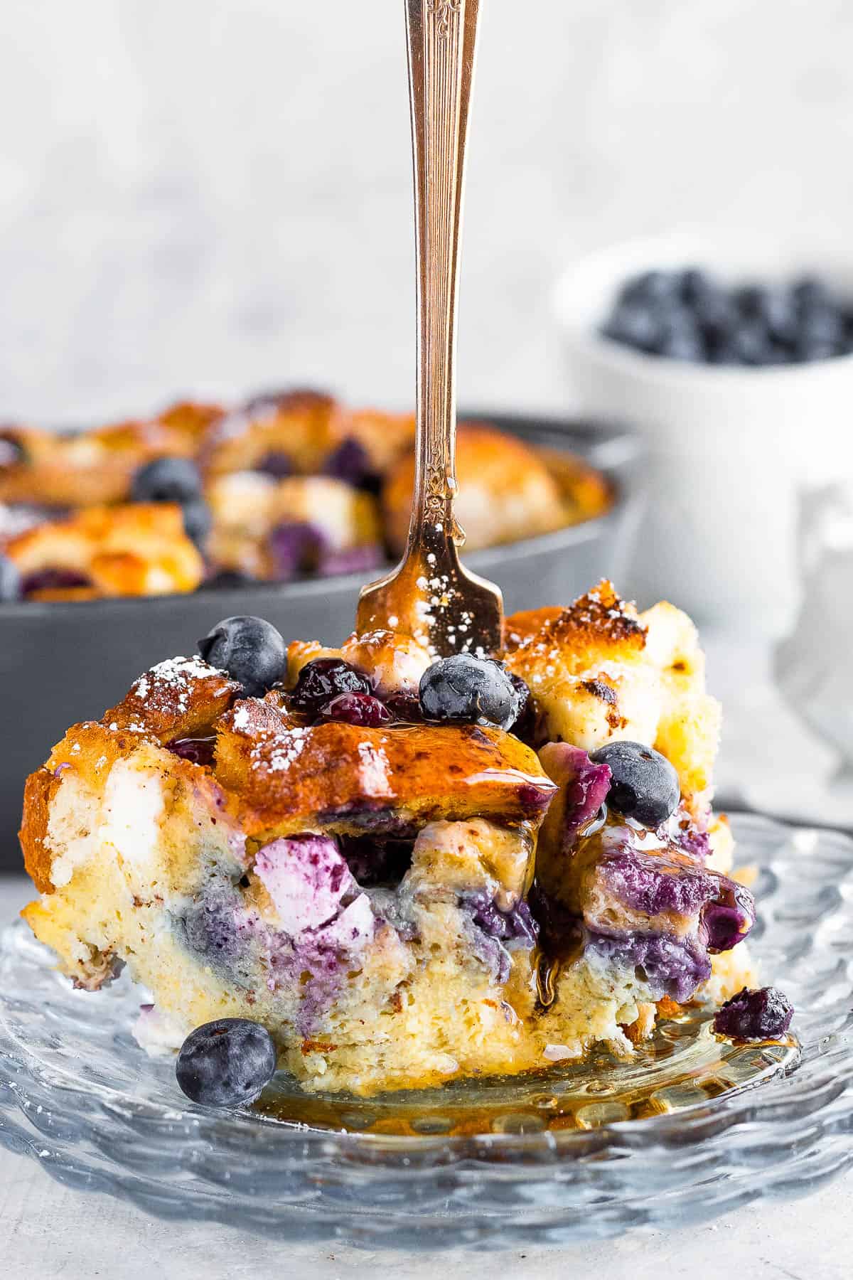 A Piece of Blueberry Casserole with a Fork Sticking Upright Into it