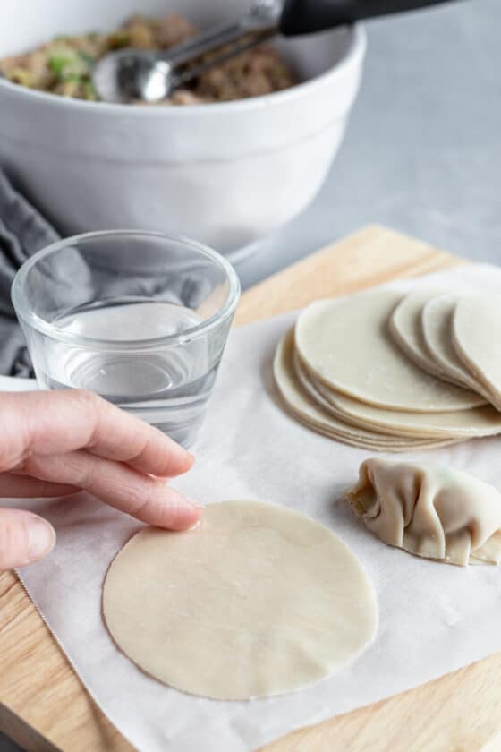 Water Being Rubbed on a Round Asian Dumpling Wrapper