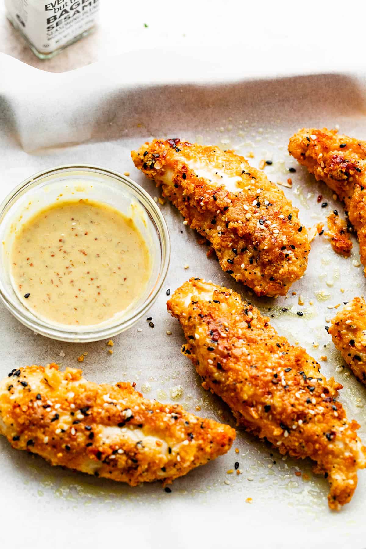 Everything Bagel Chicken Tenders on a white background served with dipping sauce