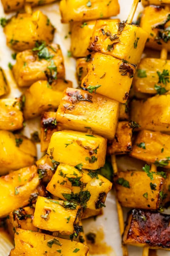 close up shot of grilled pineapple skewers served on a plate