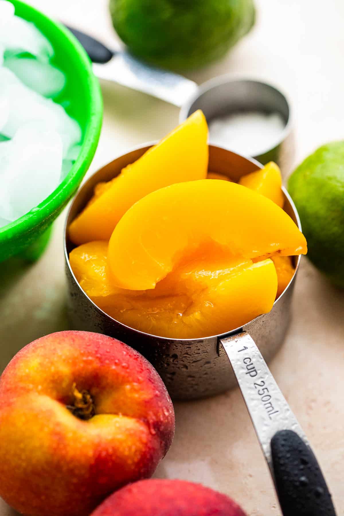 fresh sliced peaches in a stainless measuring cup