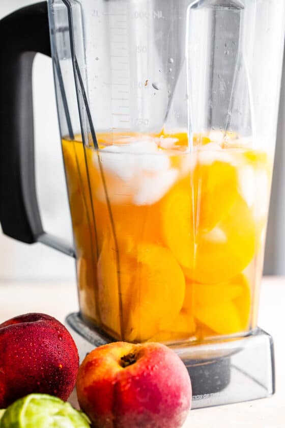 fresh peaches, rum, and ice in a blender
