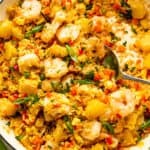 White cast iron skillet with Shrimp Fried Rice and pineapple chunks