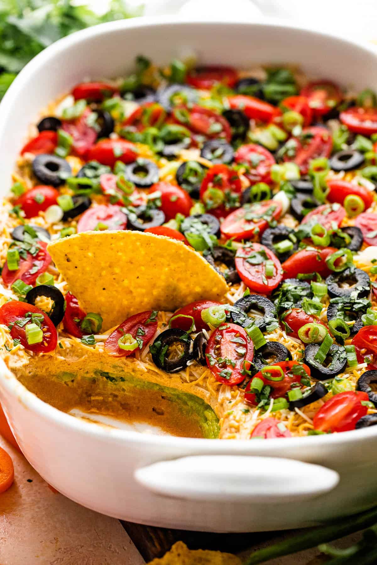 side shot of a white baking dish with seven layer mexican dip