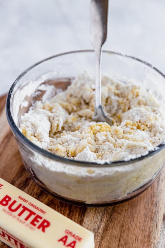 The Dough for the Cobbler Topping Being Mixed in a Glass Bowl Beside a Stick of Butter