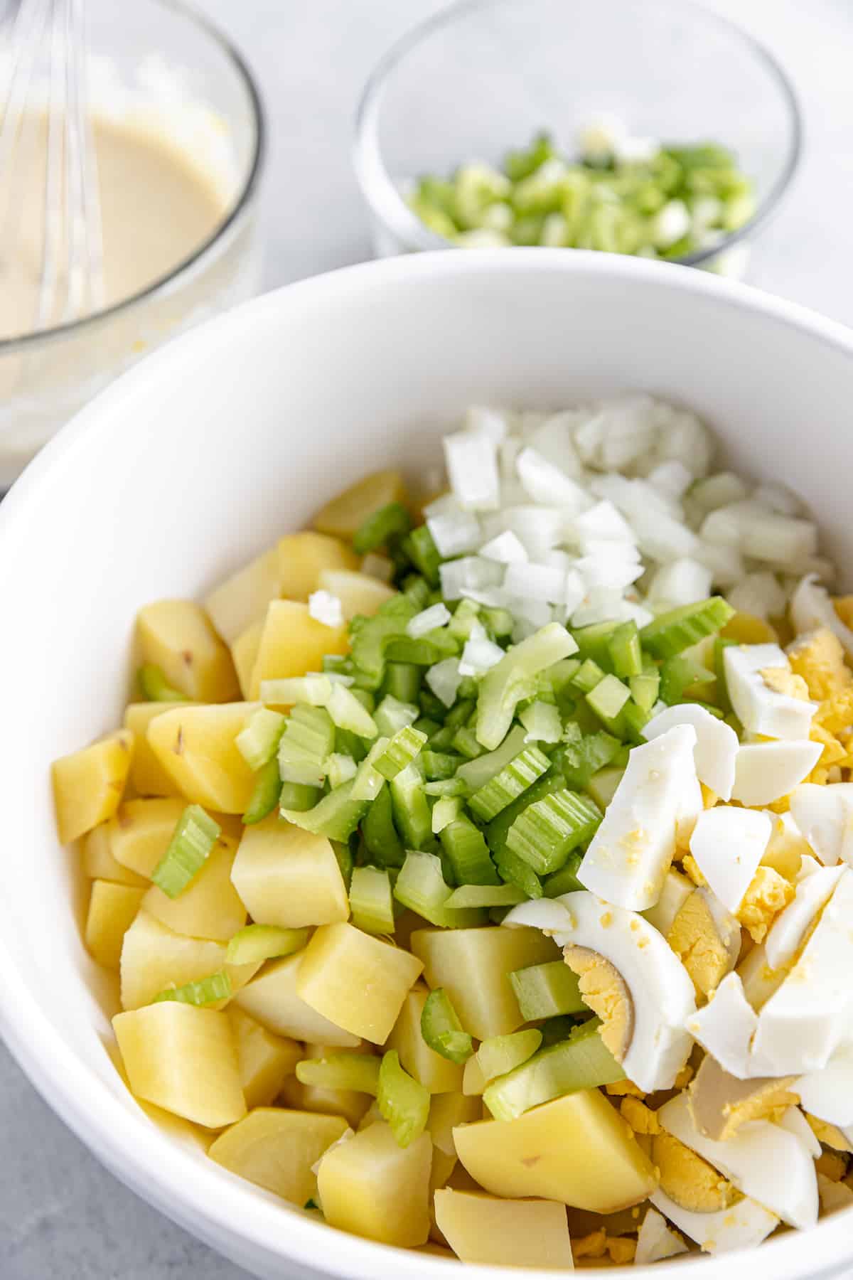 A White Bowl Filled with Uncombined Potato Salad Ingredients