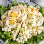 A Big Plate of Salad with Smaller Plates Stacked in the Background