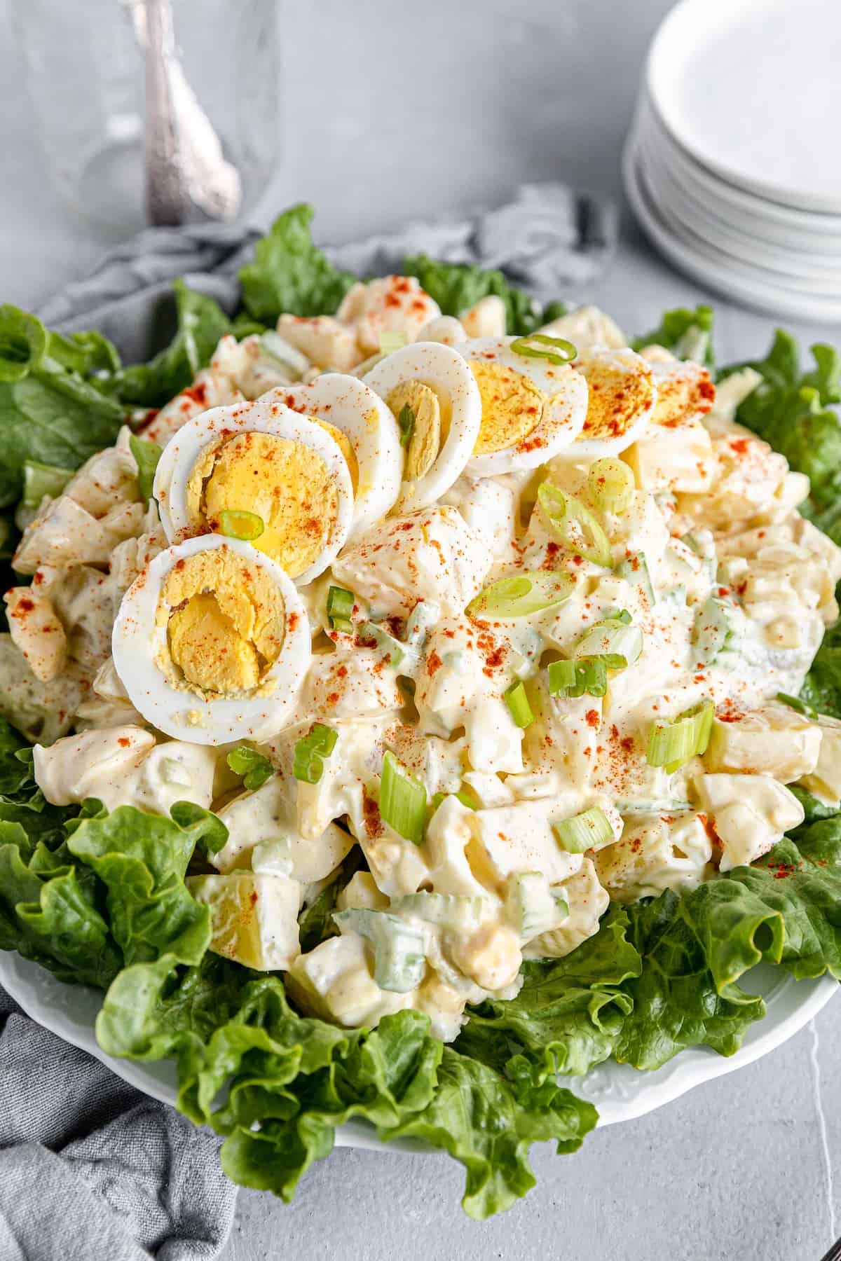 A Big Plate of Salad with Smaller Plates Stacked in the Background