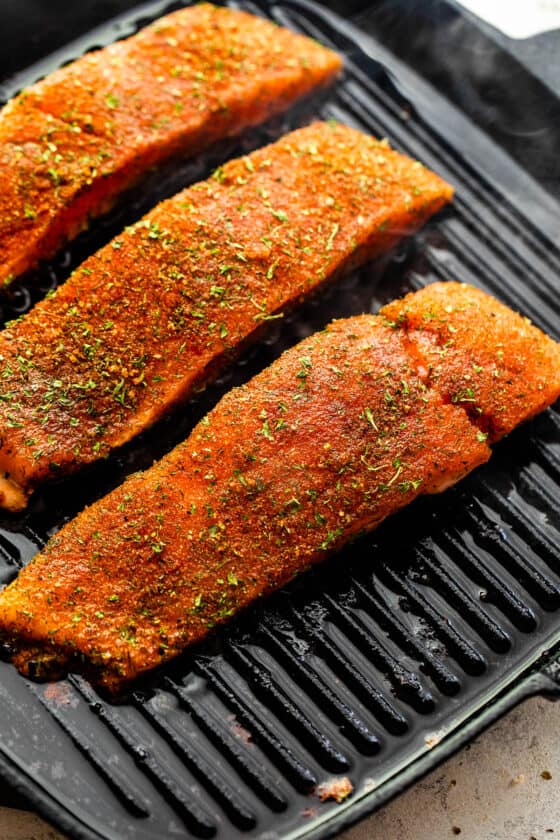 grilling salmon fillets on a black grill pan
