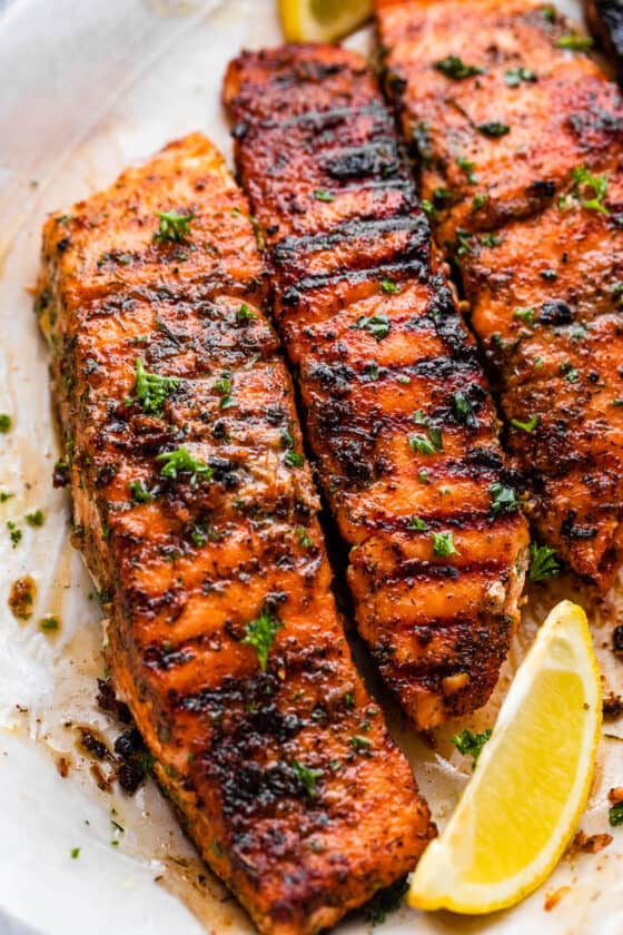grilled salmon fillets on a plate with lemon wedges