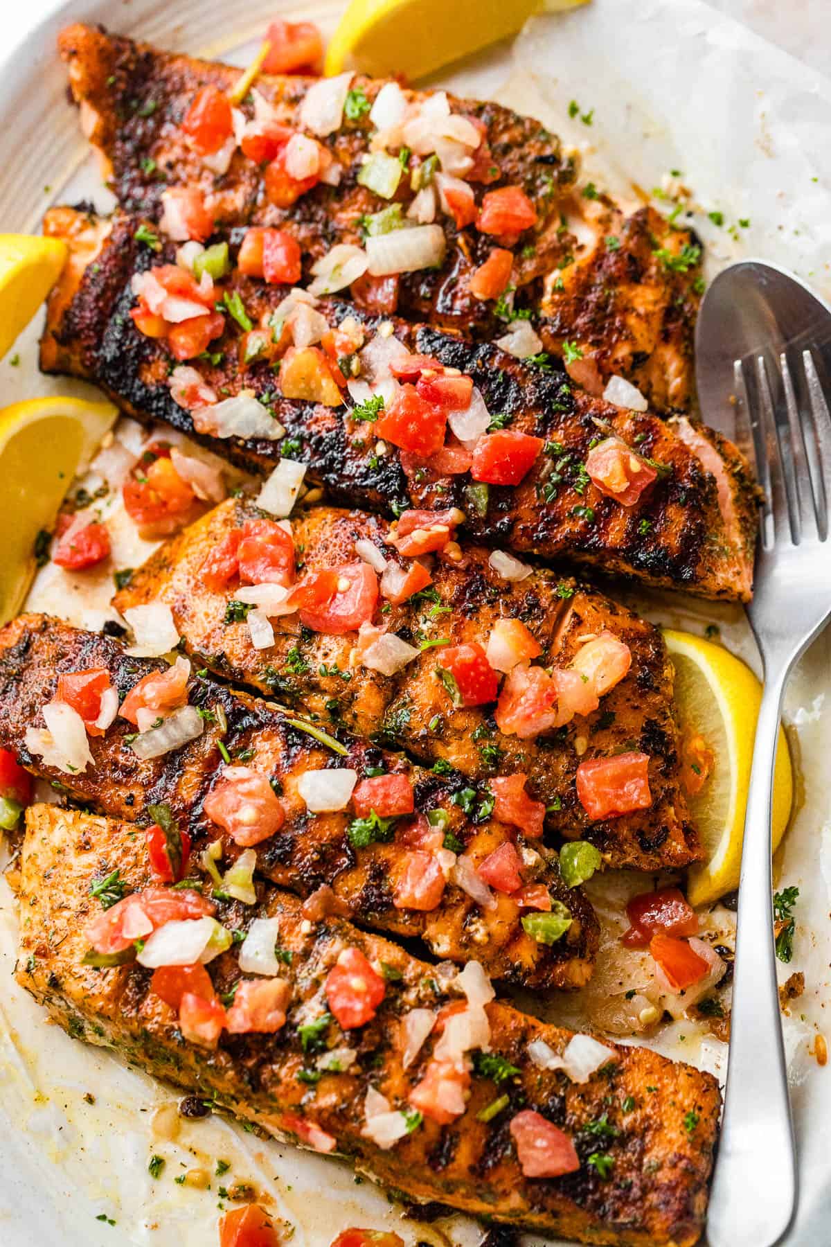 overhead shot of brown sugar grilled salmon fillets topped with diced tomatoes and onions