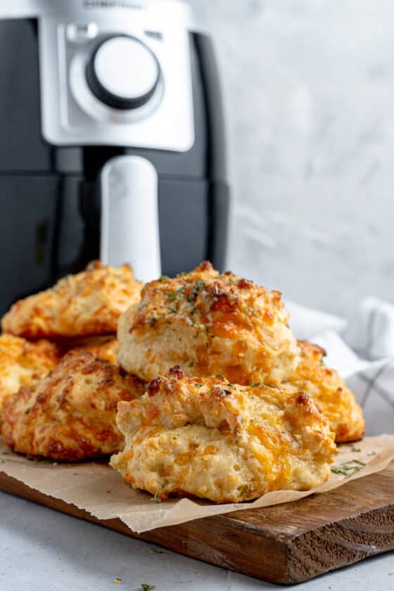 A Pile of Red Lobster Biscuits on a Cutting Board with an Air Fryer in the Background