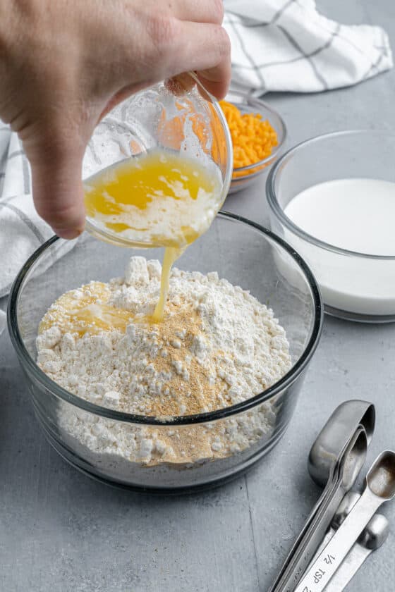 Melted Butter Being Poured Over a Bowl of Bisquick Mix