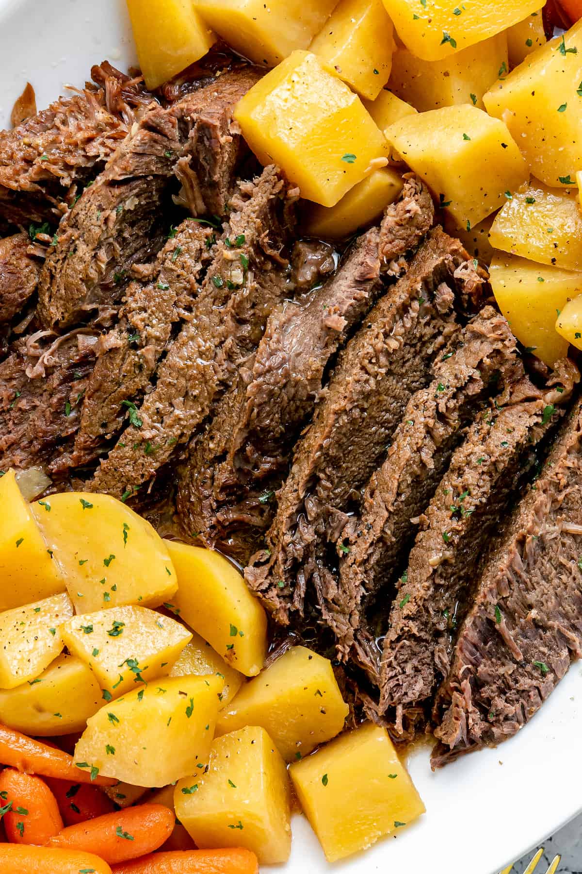 Pot roast with potatoes on a white plate