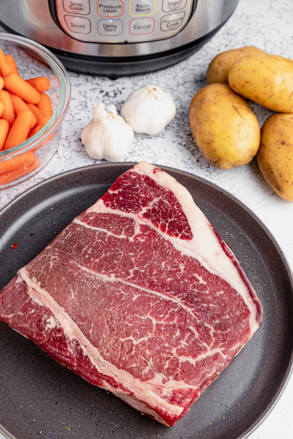 steak, potatoes, garlic and carrots