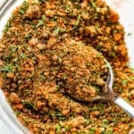 seafood seasoning blend in a small glass mixing bowl with a teaspoon inside