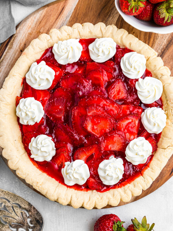 overhead shot of strawberry pie garnished with dollops of cream