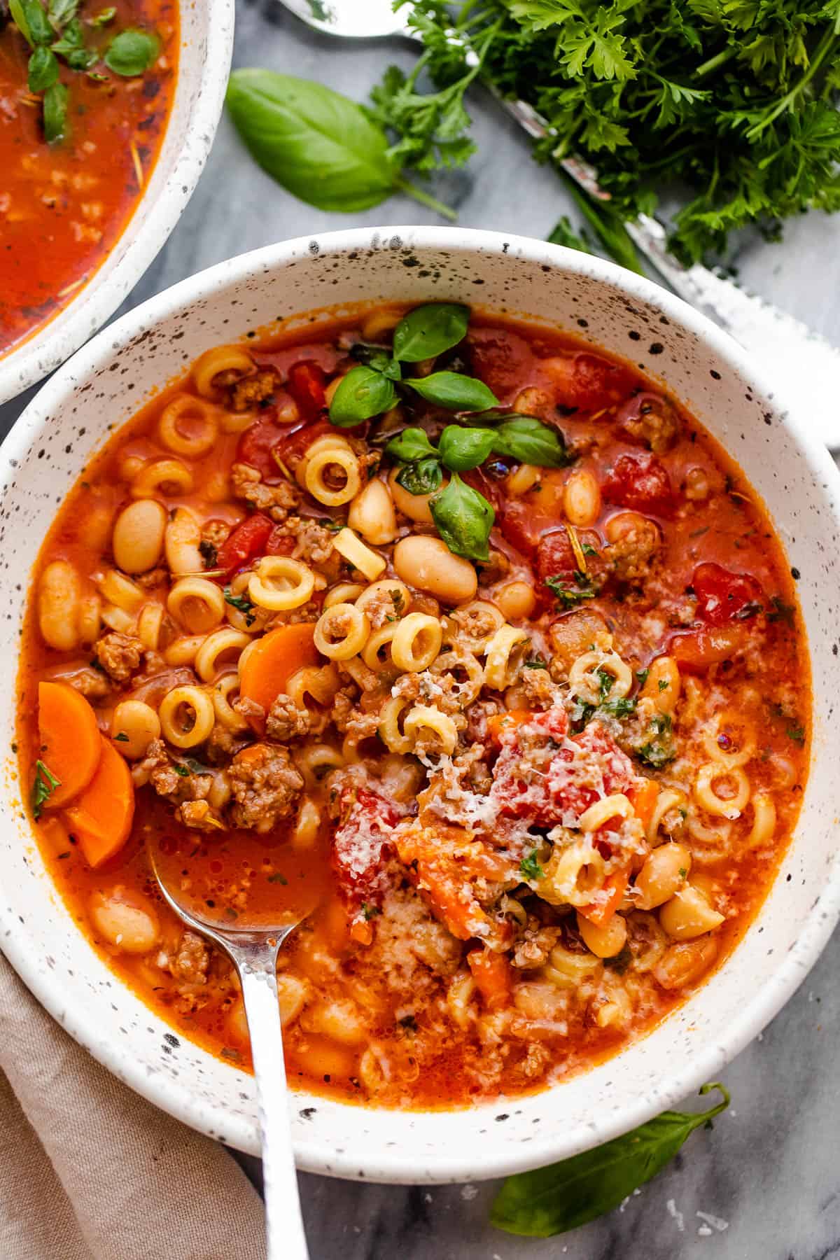overhead shot of pasta fagioli served in a bowl with a spoon