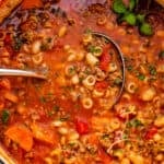 pasta fagioli soup in a white dutch oven with ladle inside the soup