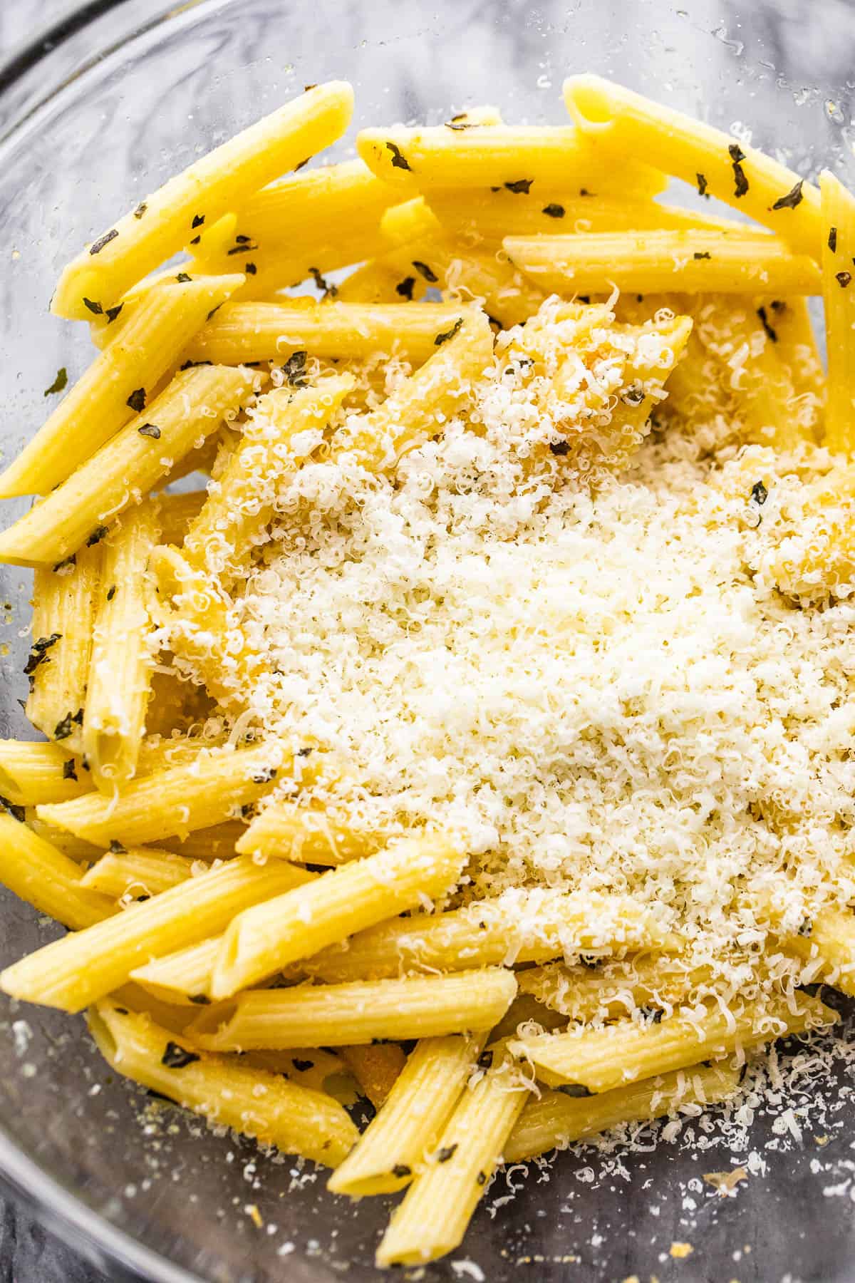 bowl with boiled pasta and a mount of parmesan cheese in the middle of it.