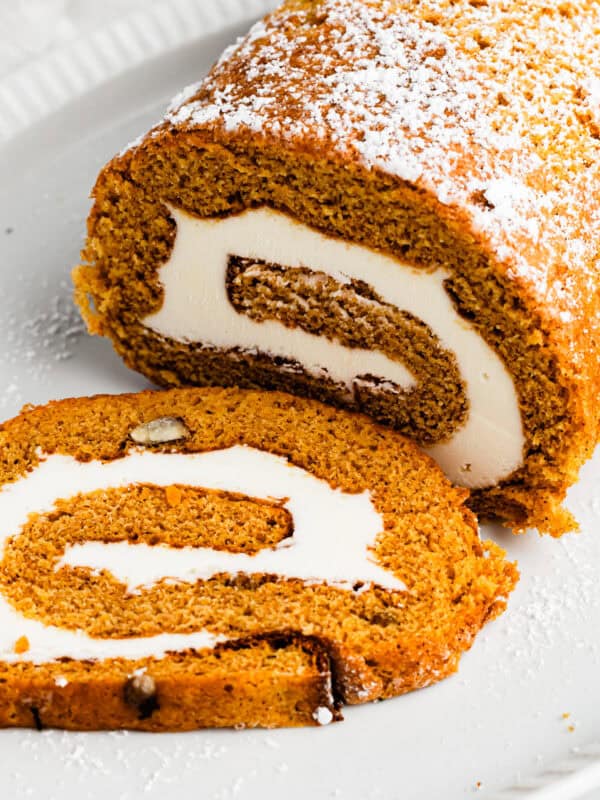 Pumpkin cake roll with one slice cut out and the filling exposed.