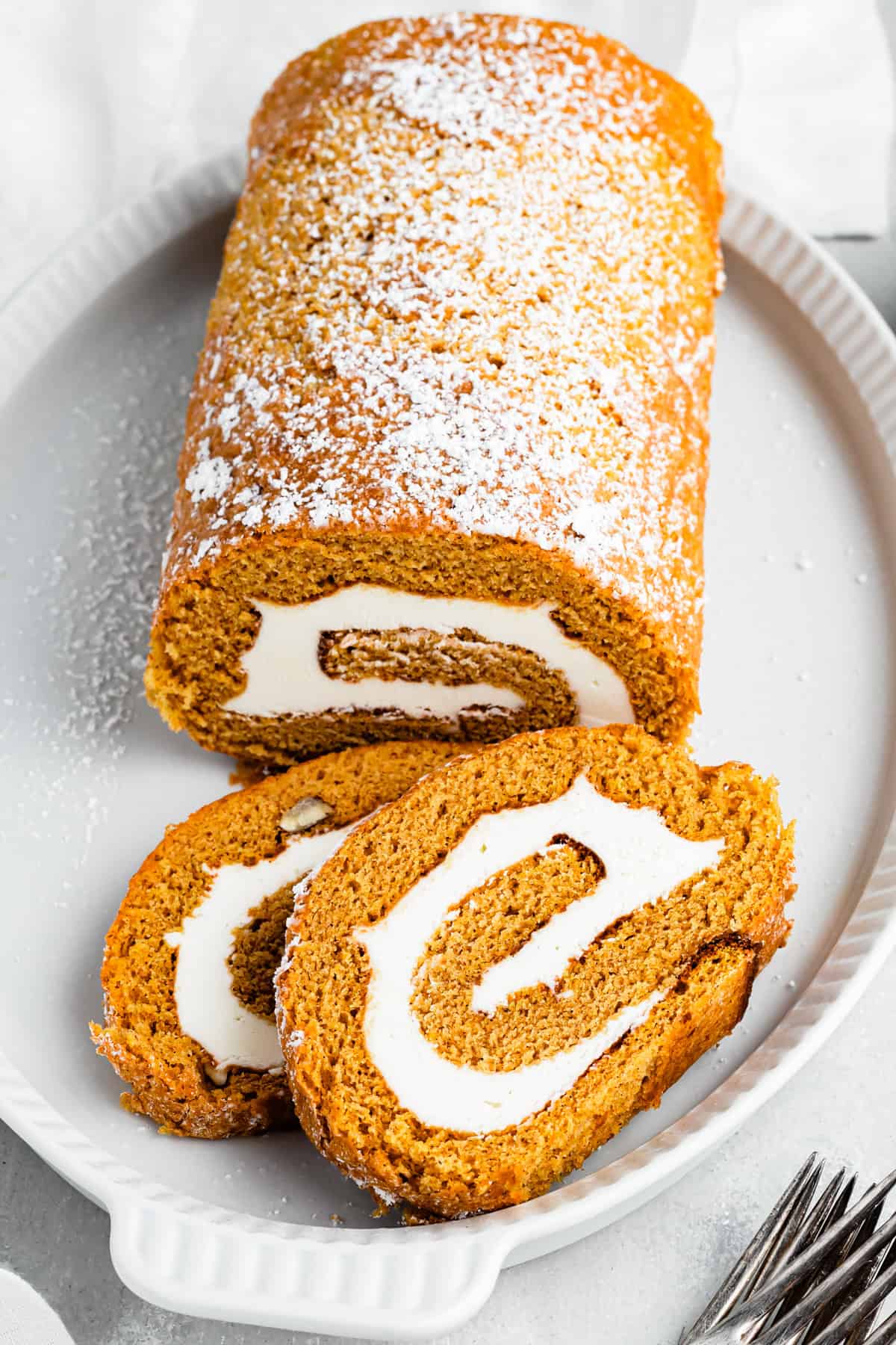 A pumpkin roll served on a platter.