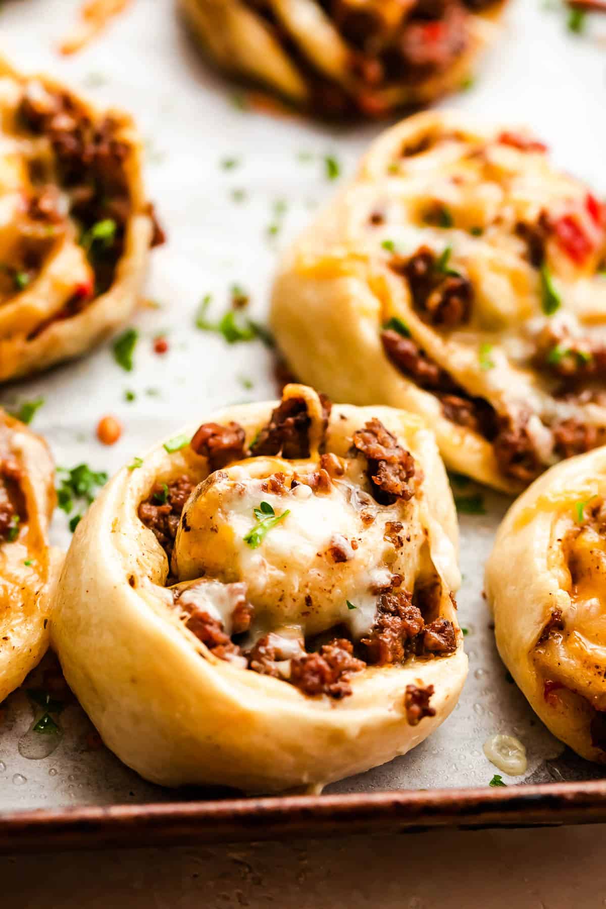 cooked taco pinwheels on a baking sheet.