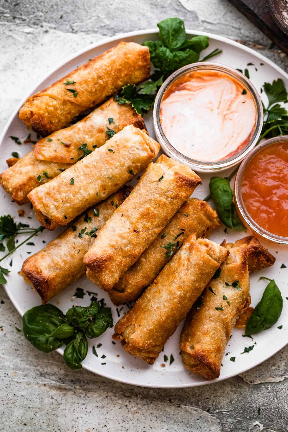 A plate of spring rolls with dipping sauce.