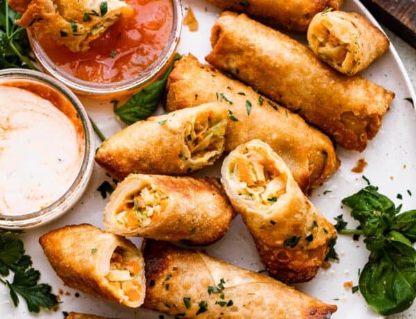 A plate of spring rolls with dipping sauce.