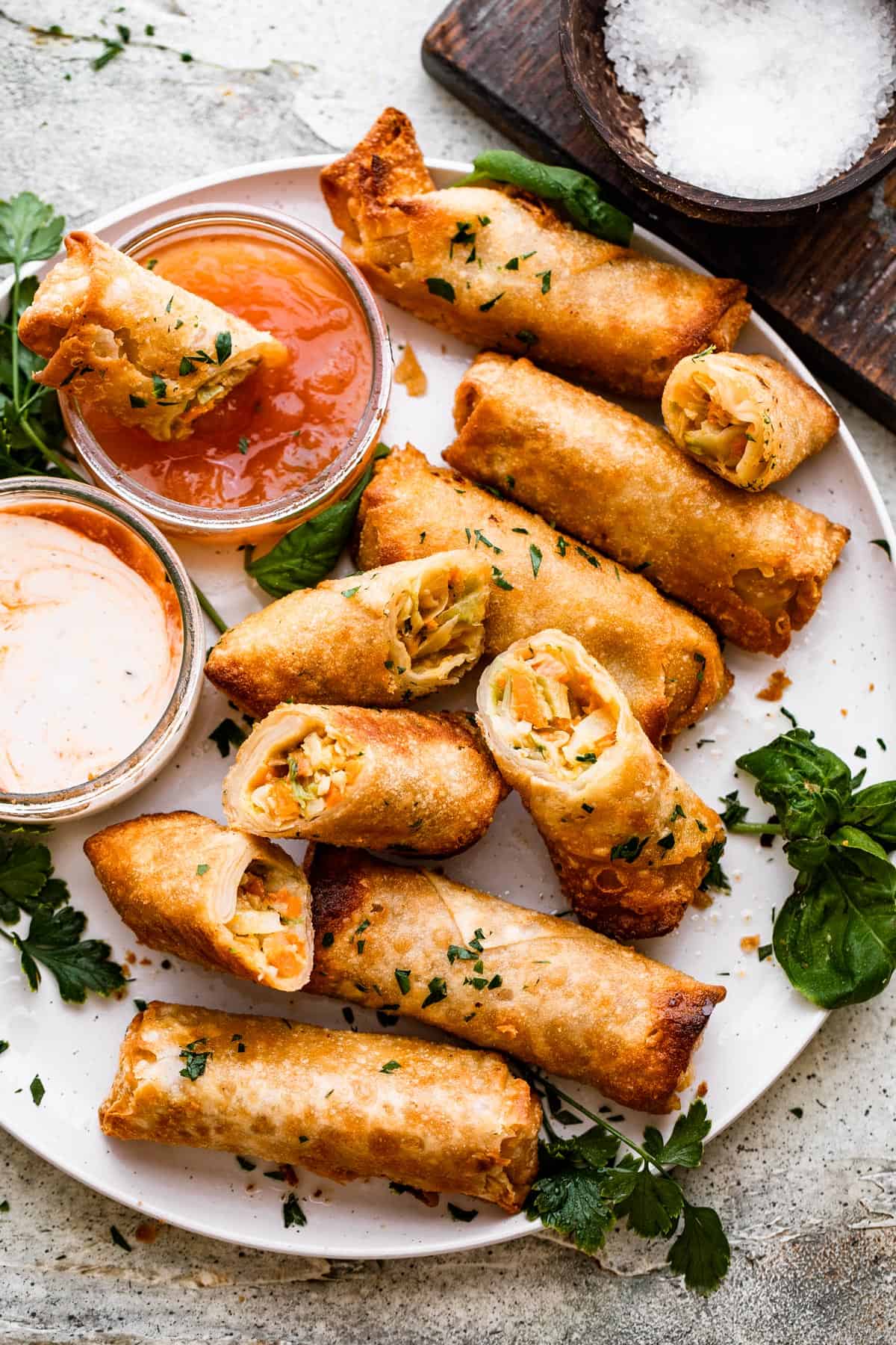 A plate of spring rolls with dipping sauce.